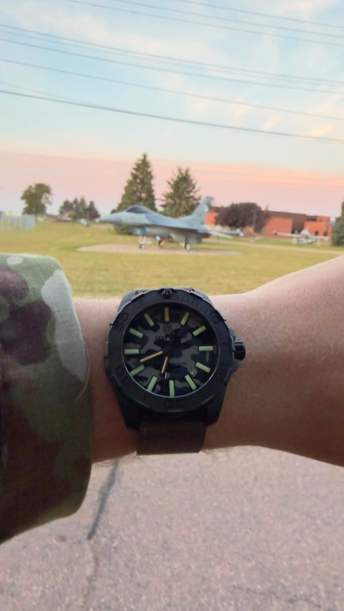 The prize watch on the winner's wrist in front of an F-16 static display